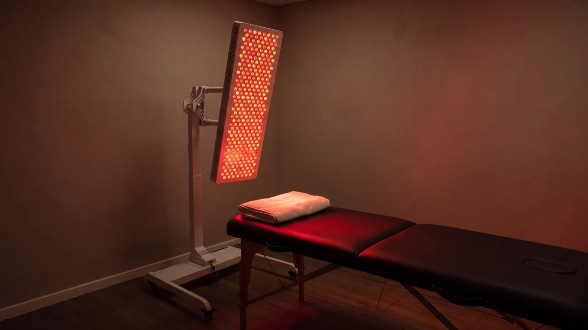 Sala de fisioterapia preparada, con un panel ESPEKTRON encendido en su soporte junto a la camilla